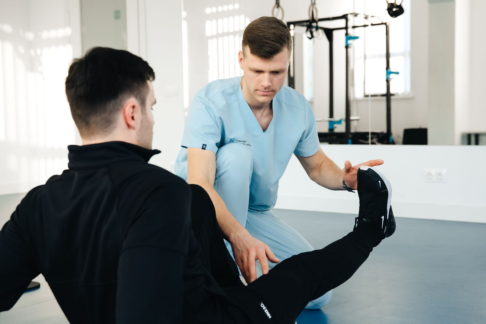 Physiotherapist examining a patient’s knee during an orthopaedic rehabilitation session