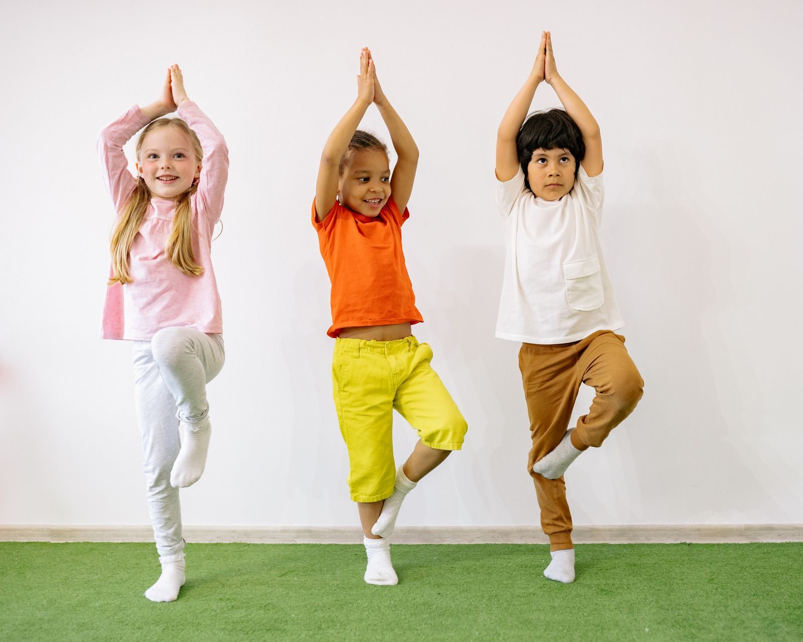 Children practising balance exercises together during a paediatric movement session