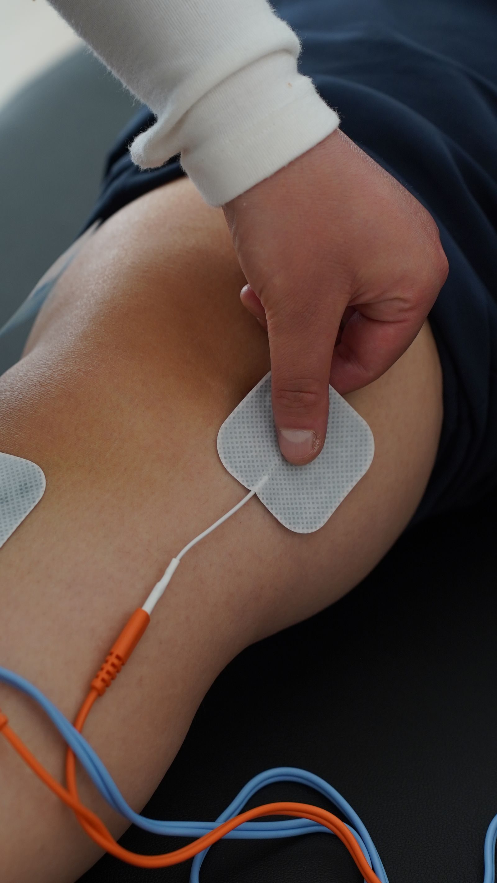 Electrode pads for electrotherapy placed on a patient’s back during a session