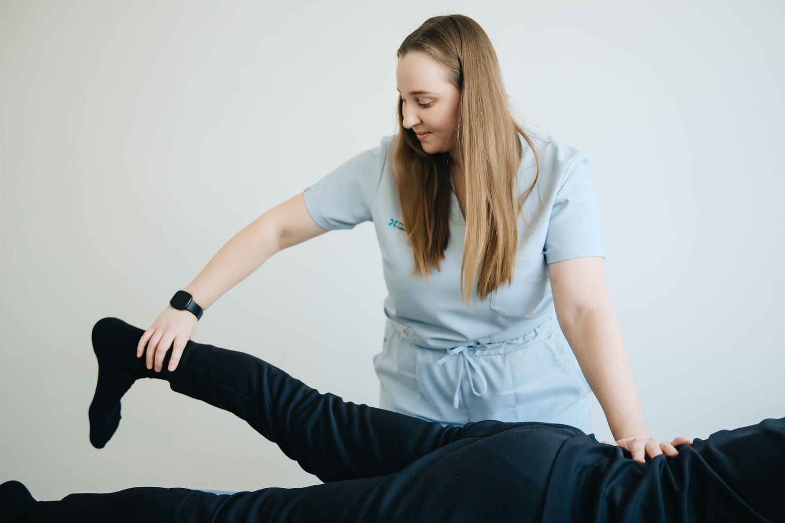Physiotherapist performing hands-on manual therapy on a patient’s leg