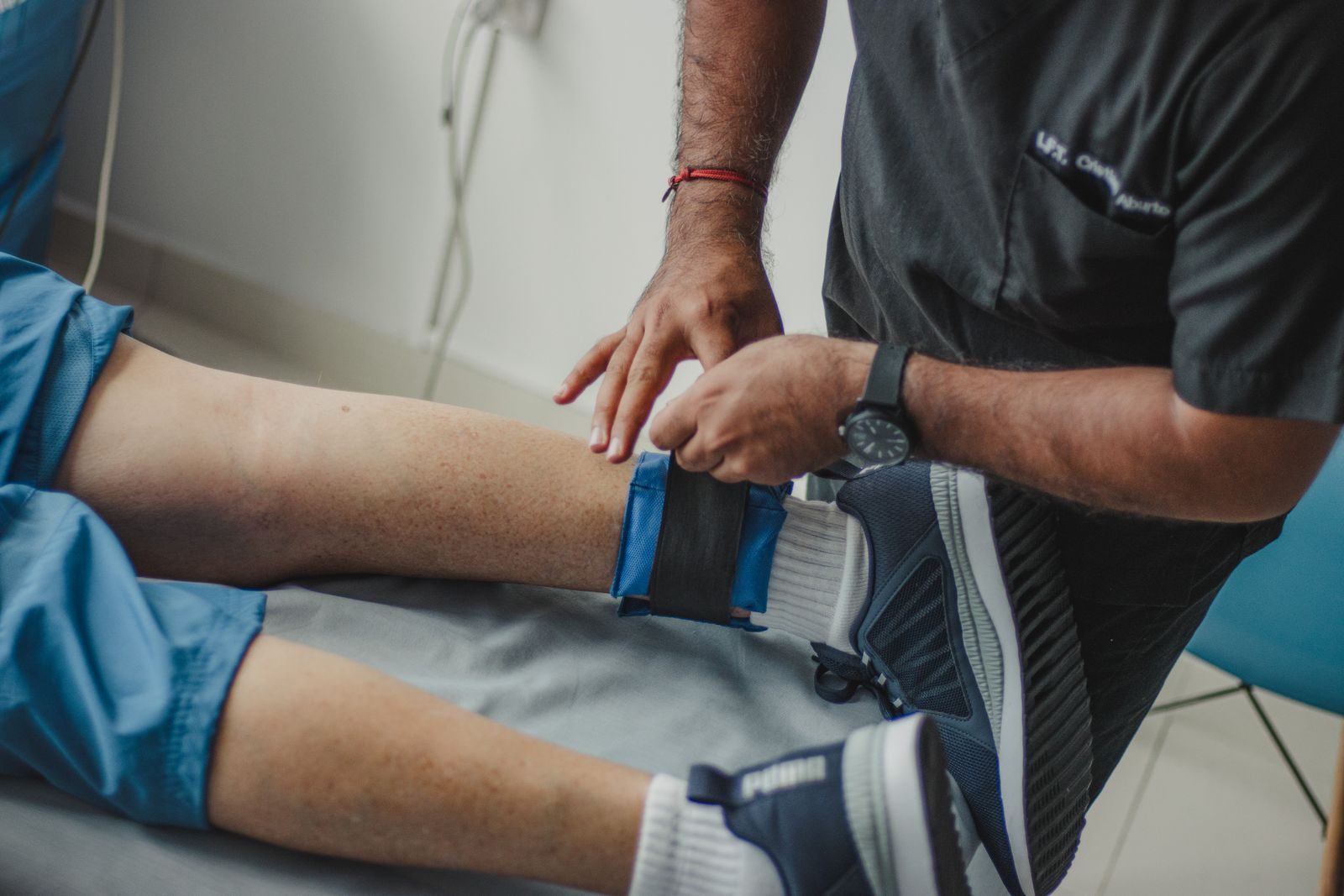 Therapist adjusting a supportive strap on a patient’s leg during traction-style therapy
